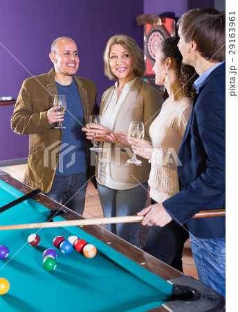 Adults with wine at billiard table. Adults with wine at billiard table. 29163961