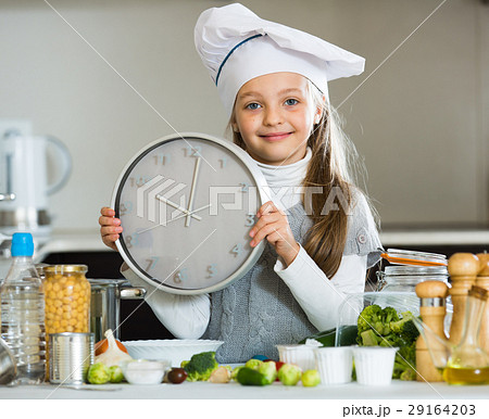 Portrait of sweet little girl with veggies and clock Portrait of sweet little girl with veggies and clock 29164203