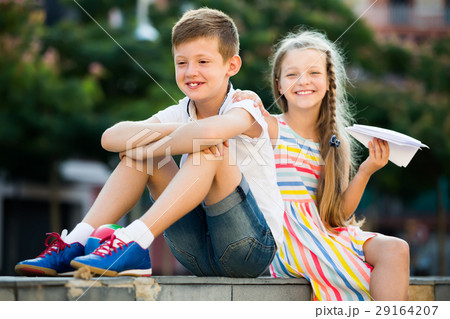 happy girl and boy sitting together in park 29164207