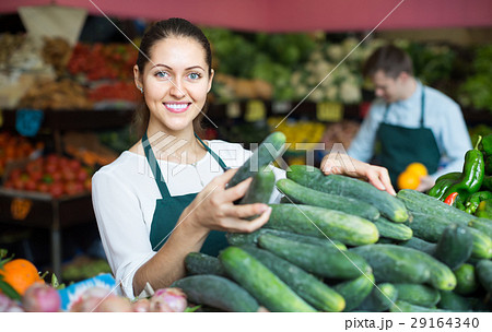 Stuff in apron selling green cucumber at marketplace Stuff in apron selling green cucumber at marketplace 29164340