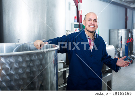 mature man working in wine fermentation section. mature man working in wine fermentation section. 29165169