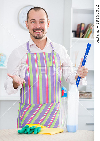 Young man in apron cleaning table 29166002