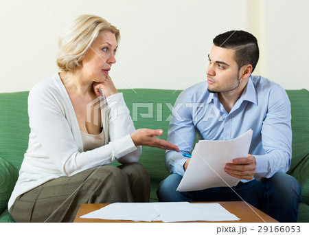 Elderly woman and young man with bills. Elderly woman and young man with bills. 29166053
