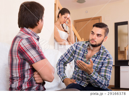 Girl watching two guys arguing indoors 29166378