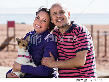 Mature couple with a small dog outdoors. Mature couple with a small dog outdoors. 29166426