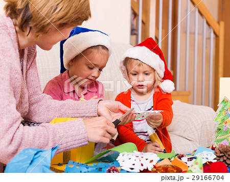 mother with two daughters preparing for Christmas 29166704