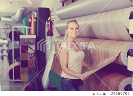 cheerful woman customer choosing linoleum flooring in hypermarket 29166705