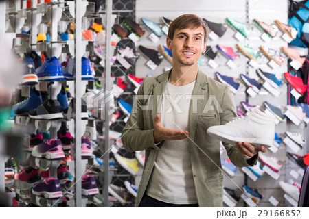 young man showing shoes in the sport store 29166852