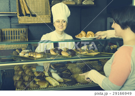 Woman choosing pastry in cafe showcase Woman choosing pastry in cafe showcase 29166949