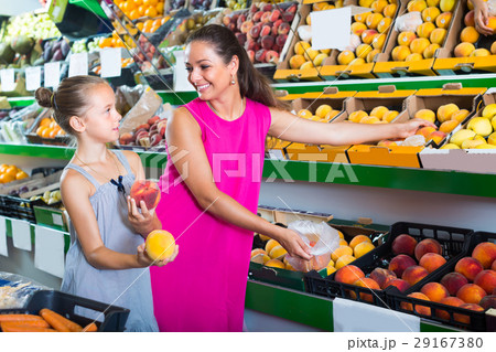 mother with girl taking peaches on market . 29167380