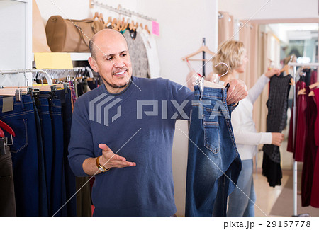 spouses buying pair of classic jeans in boutique spouses buying pair of classic jeans in boutique 29167778