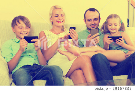 Portrait of family playing with gadgets at home Portrait of family playing with gadgets at home 29167835