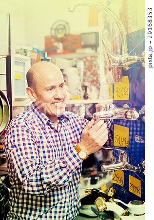 Mature positive man selecting heating water tap in store Mature positive man selecting heating water tap in store 29168353