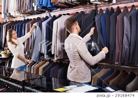 Couple deciding on new suit in men’s cloths store 29168474
