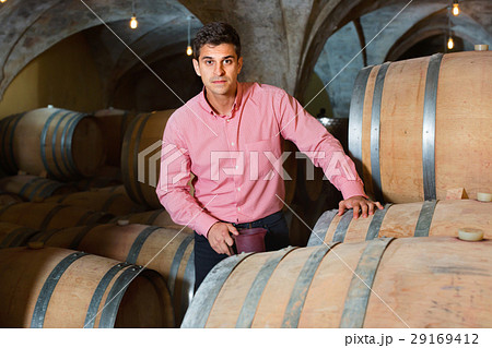 Male customer tasting red wine from wooden barrels Male customer tasting red wine from wooden barrels 29169412