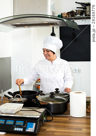 Woman chef cooking food at cafe's kitchen 29169776