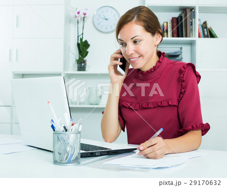 Woman taking notes while talking Woman taking notes while talking 29170632