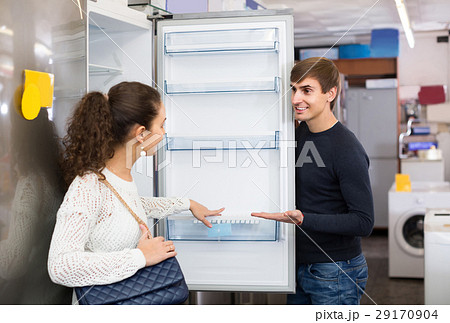 family couple choosing new refrigerator in hypermarket family couple choosing new refrigerator in hypermarket 29170904