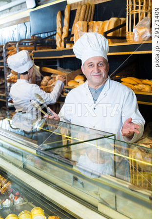 two bakers at the counter at bakery. 29171409