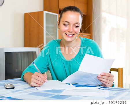 Girl with papers at the table at home Girl with papers at the table at home 29172211
