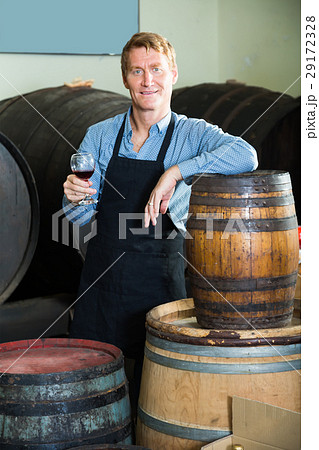 friendly seller male wearing apron suggesting to try glass of wine 29172328