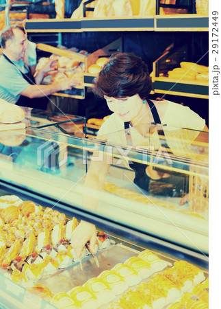 mature female baker with fresh bread in bakery 29172449