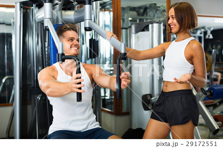 Female coach assisting man using fly machine 29172551