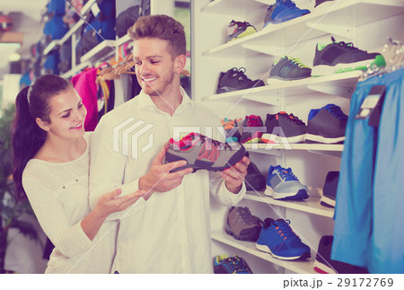 loving couple deciding on new sneakers in sports store loving couple deciding on new sneakers in sports store 29172769
