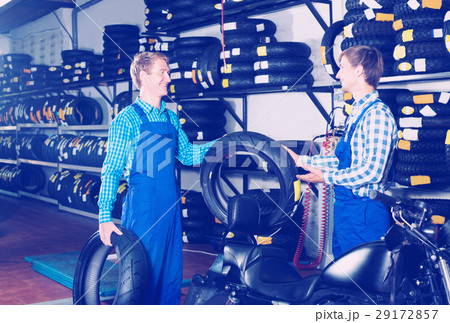 Two male professionals standing with new tires 29172857