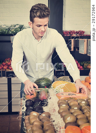 Man choosing fruits in grocery shop 29172964
