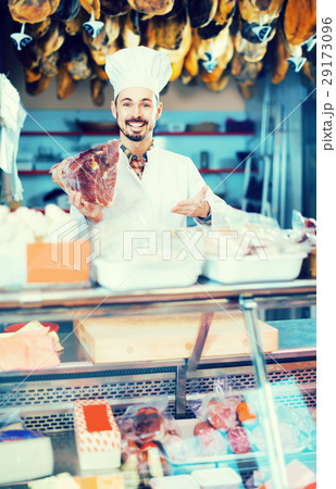 Male shop assistant demonstrating piece of meat in butcher’s shop Male shop assistant demonstrating piece of meat in butcher’s shop 29173096