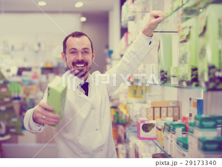 Smiling man pharmacist offering right drug 29173340