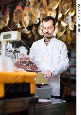 Positive man assistant weighing piece of meat Positive man assistant weighing piece of meat 29173728