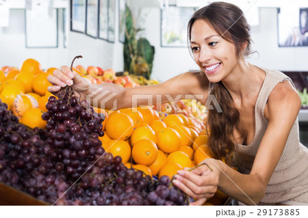 Young female customer buying sweet ripe grapes 29173885