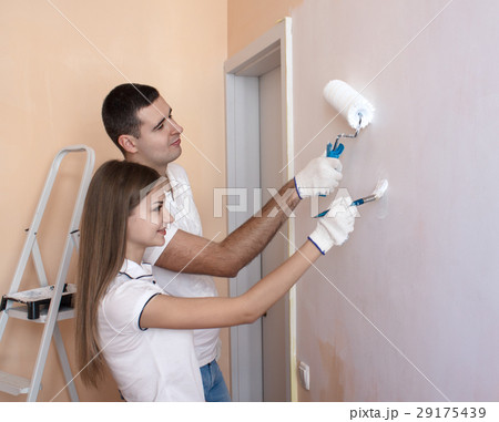oung couple painting interior wall of new house 29175439