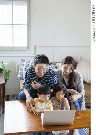 リビングでパソコンを囲む家族4人 29179837
