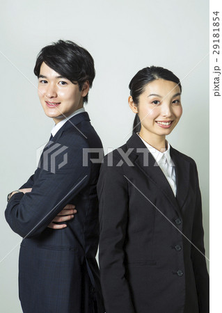 背中を合わせるスーツ姿の20代男女 29181854