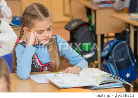 A girl pupil in the classroom at school looking  29186513