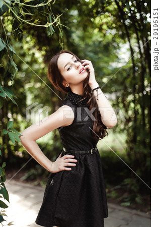 Beautiful young girl in black dress with long hair Beautiful young girl in black dress with long hair 29196151