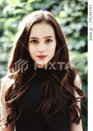 Beautiful young girl in black dress with long hair Beautiful young girl in black dress with long hair 29196161