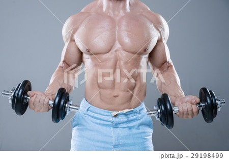 Brutal strong bodybuilder man posing in studio on grey backgroun Brutal strong bodybuilder man posing in studio on grey backgroun 29198499