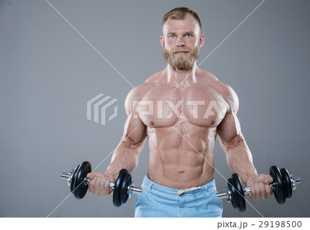 Brutal strong bodybuilder man posing in studio on grey backgroun Brutal strong bodybuilder man posing in studio on grey backgroun 29198500