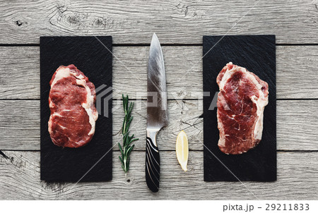 Raw beef steaks on dark wooden table background 29211833