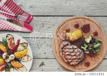 Grilled beef steak closeup on dark wooden table Grilled beef steak closeup on dark wooden table 29211933