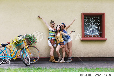 Happy boho chic girls pose with bicycles near Happy boho chic girls pose with bicycles near 29217316