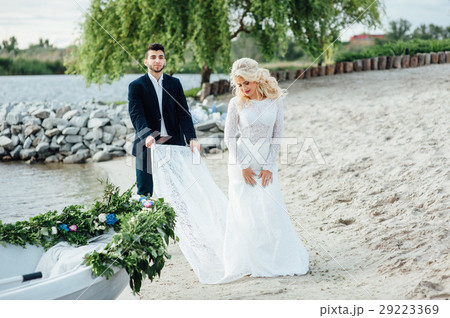 Bride and groom walking near the boat at river Bride and groom walking near the boat at river 29223369