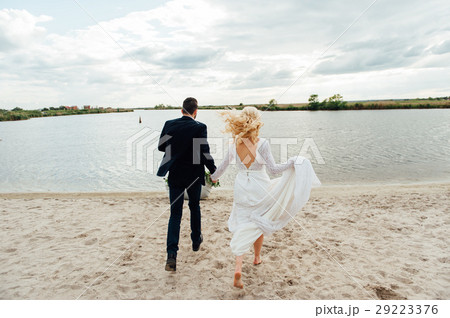 Bride and groom walking at the river 29223376