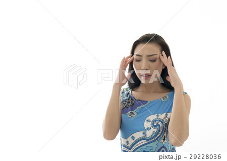 こめかみを揉む若い女性　白バック 29228036