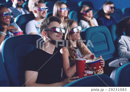 Positive couple drinking cola and eating popcorn 29231083