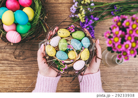 Woman hands holding painted easter egg in a small 29233938
